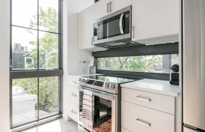 Beautiful, light filled kitchen with stainless steel appliances and oversized windows at OSLOAdmo